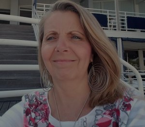 Photo of woman sitting dockside at Flying Bridge Restaurant, Falmouth, MA overlooking the menu and the harbor